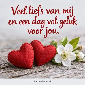 Twee rode harten en een witte bloesem op een houten tafel.