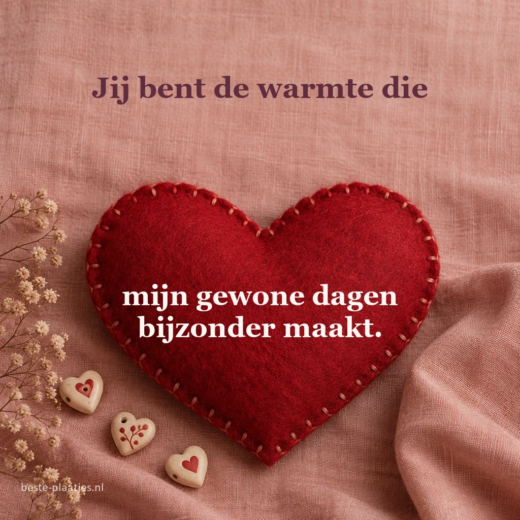 Een gestikt rood vilten hart rust op zachtroze linnen.