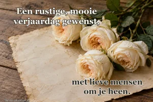 Vier roomwitte rozen liggen op oud papier op een houten tafel.